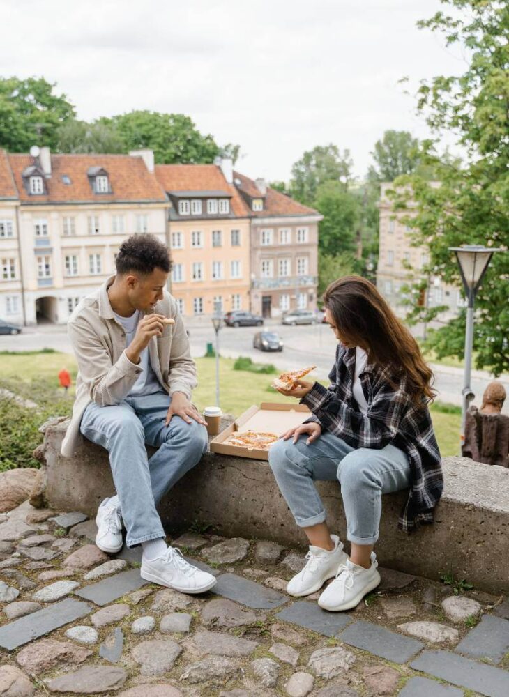 pregnant couple eating food on the street