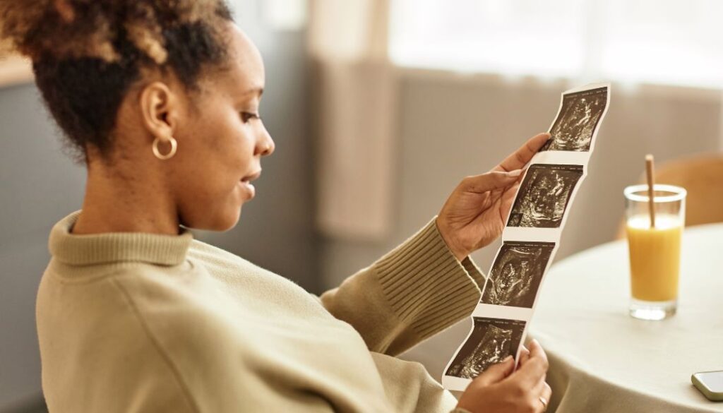 woman holding ultrasound picture