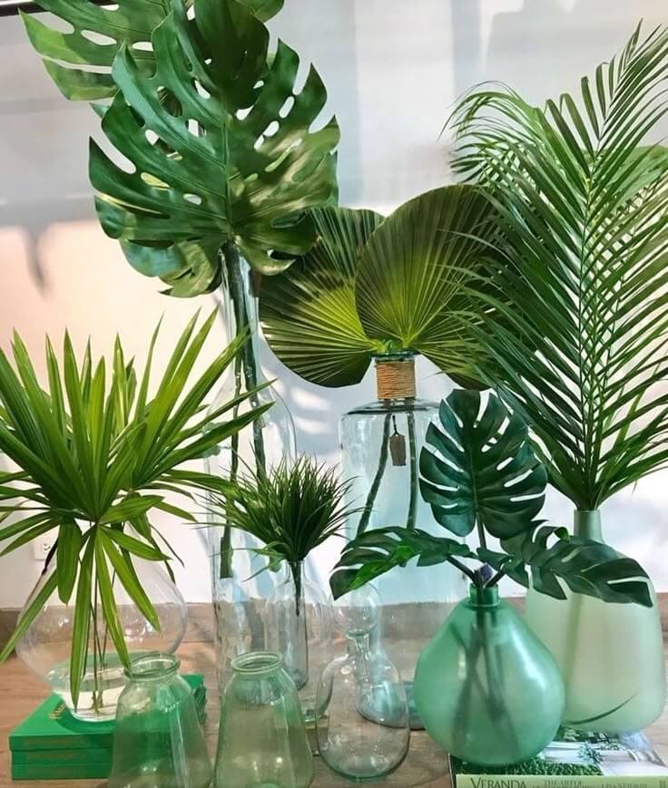 monstera leaves in colorful vases