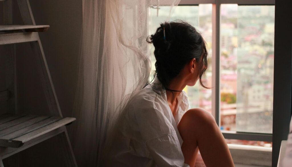 woman looking through window