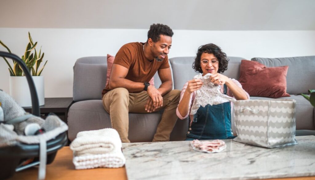 couple folding baby clothes