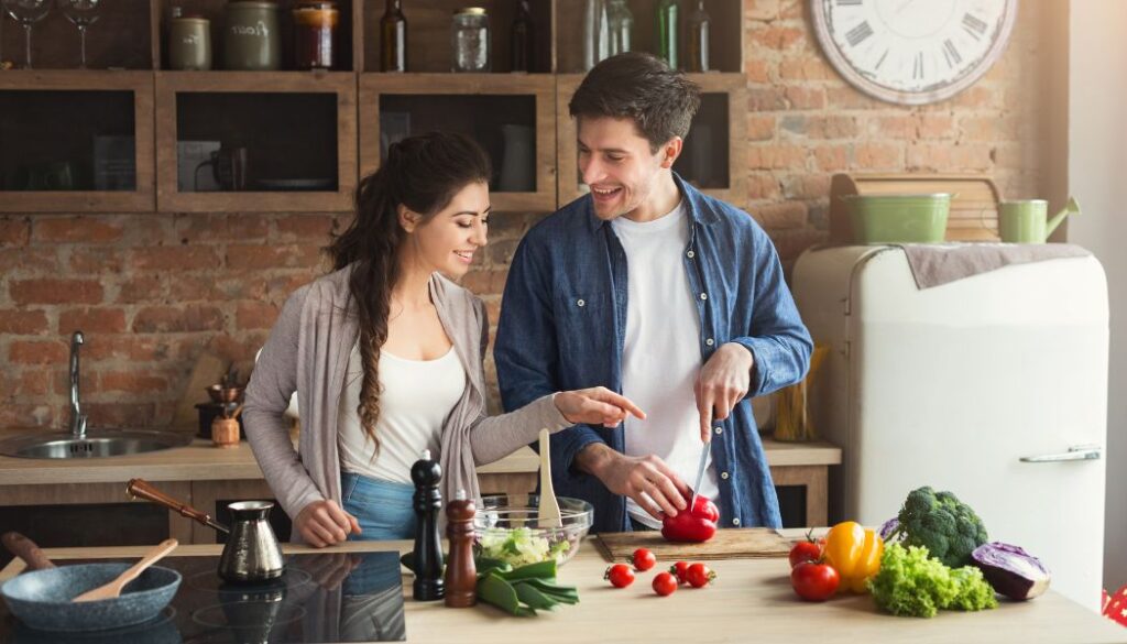 man and pregnant woman cooking together