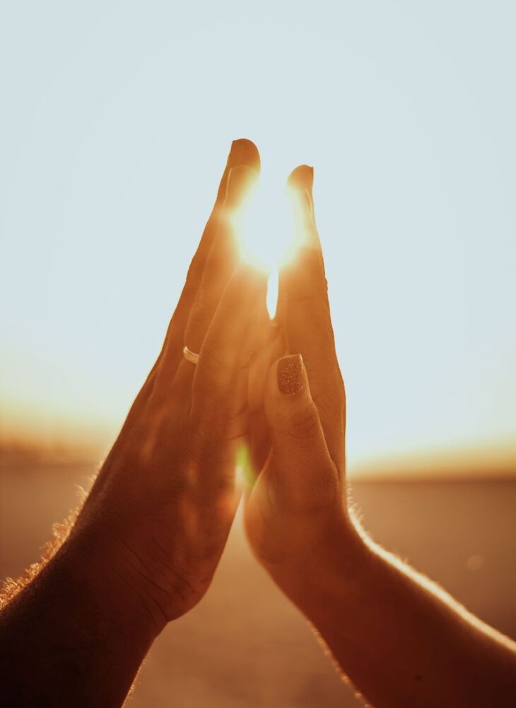 couple holding hands at sunset
