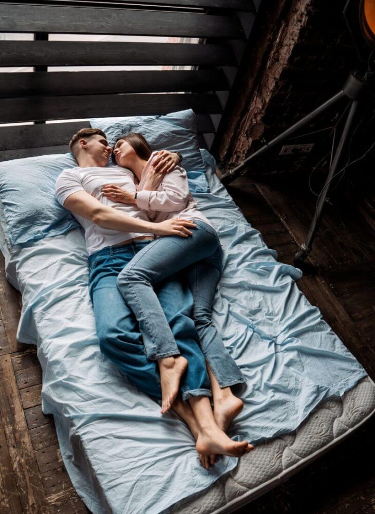 man and woman lying on a bed
