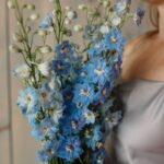 woman holding blue flowers