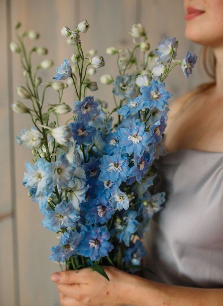 woman holding blue flowers