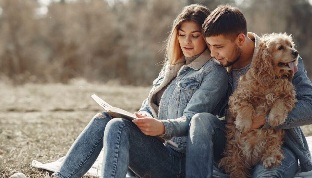 couple looking at photo album with a dog