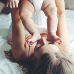 woman playing with a newborn