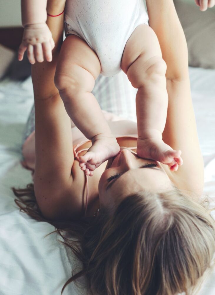 woman playing with a newborn