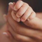 new mom holding baby’s hand