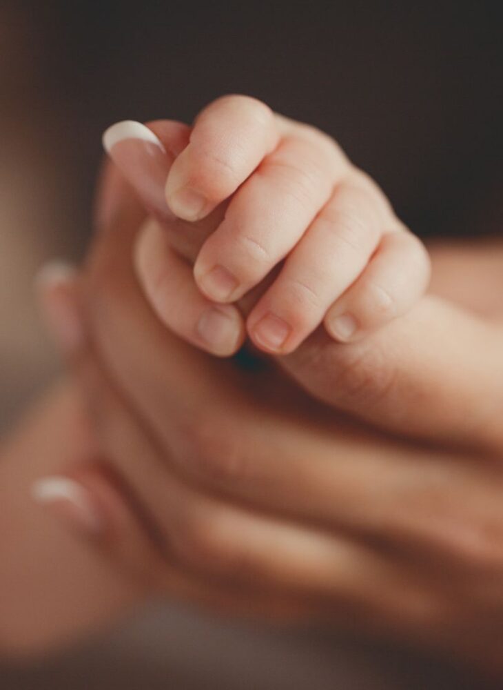 new mom holding baby’s hand